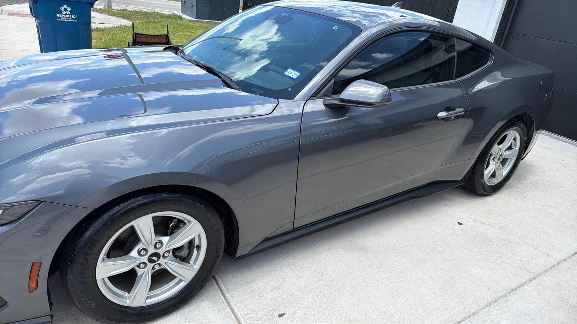Grey Ford Mustang washed and shining in a driveway