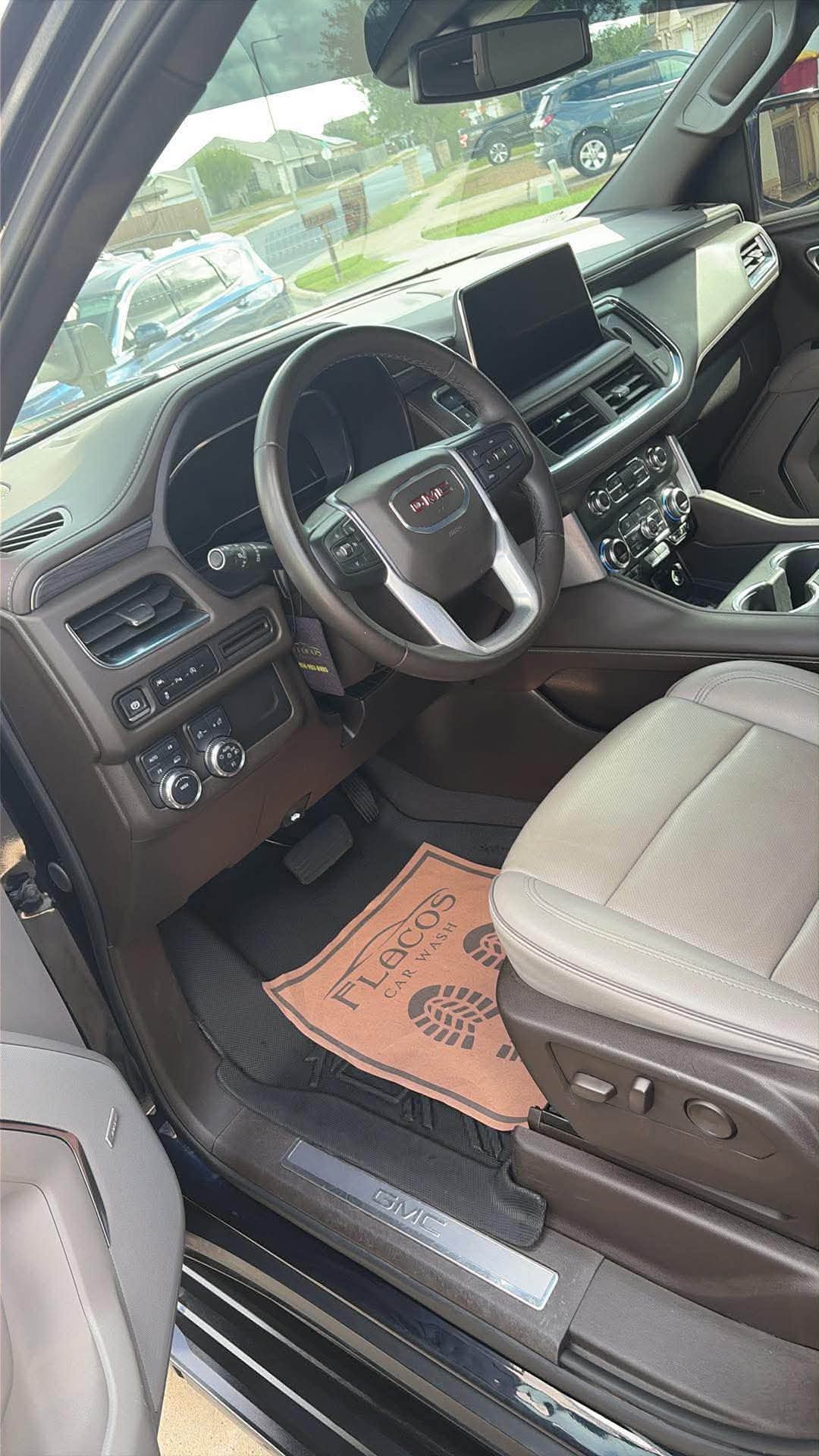 GMC Yukon interior with a Flaco's branded floor mat